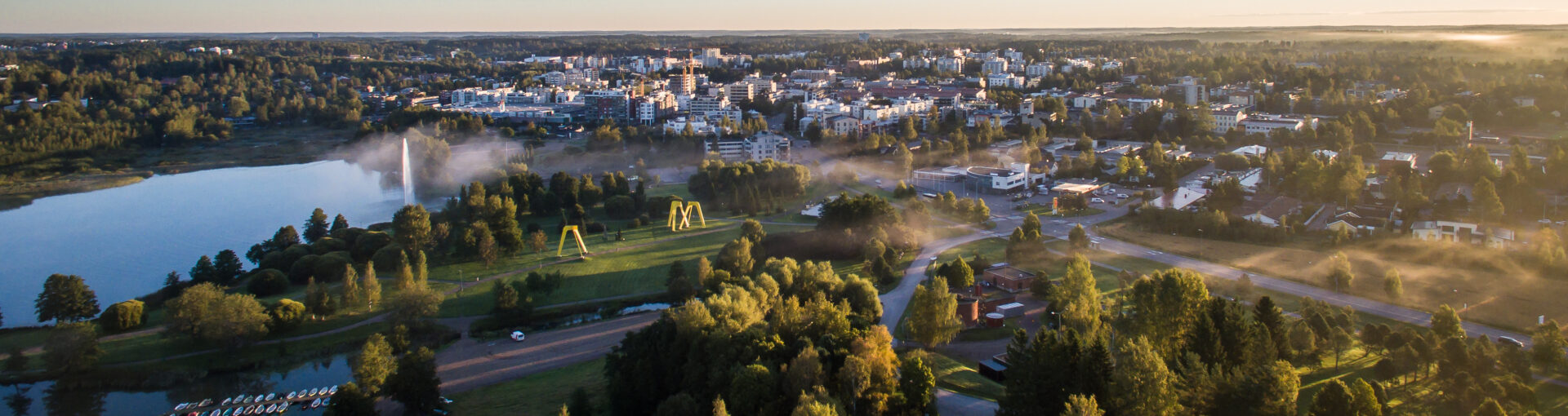 Ilmakuva Järvenpään kaupungista kesäaikaan, aamusumu kaupungin yllä.