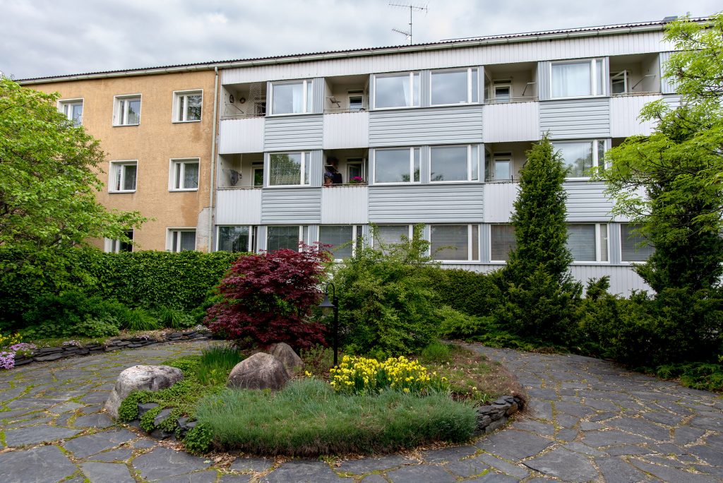 Urheilukatu 6:n (vanha kaupungintalo) kiinteistön puutarhapiha-alue. Taustalla 3-kerroksinen talo ja edessä puita ja istutuksia.