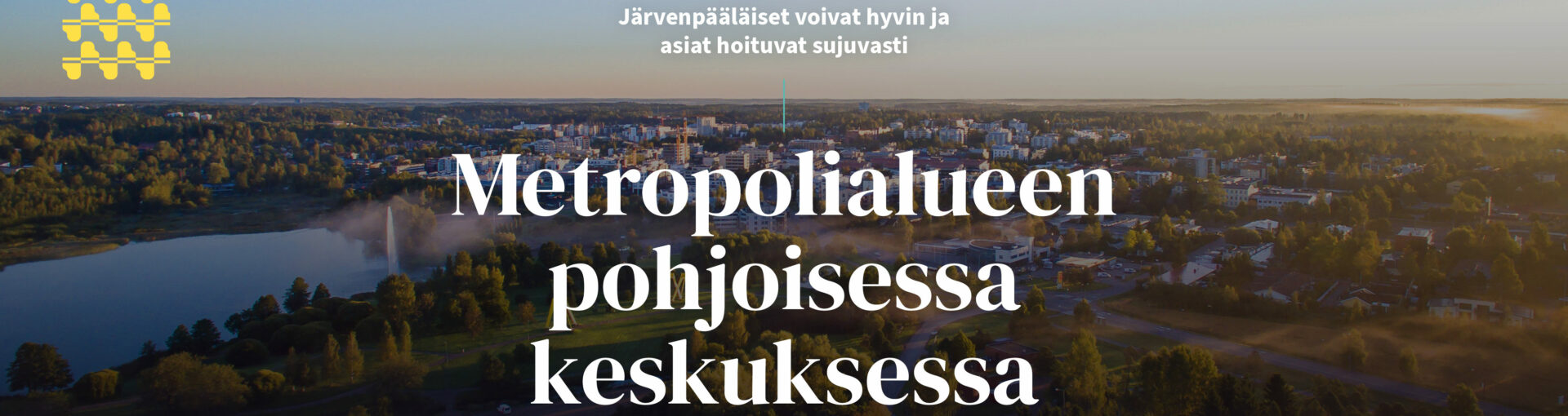 Ilmakuva kaupungista, jonka päällä tekstiä. Keskellä kuvaa teksti "Järvenpäävisio 2030: Järvenpääläiset voivat hyvin ja asiat hoituvat sujuvasti Metropolialueen pohjoisessa keskuksessa".
