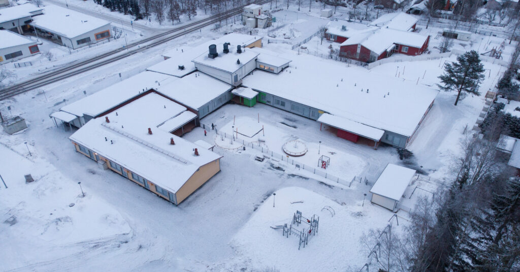 Ilmakuva lumenpeittämästä rakennuksesta.