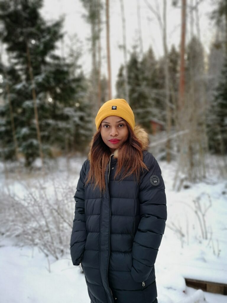 Nainen talviasussa talvisessa metsämaisemassa.