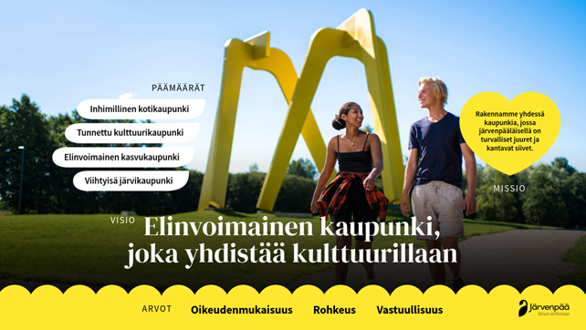Kuvassa on kaksi henkilöä, jotka kävelevät ulkona aurinkoisessa säässä suuren, keltaisen taideteoksen edessä. Tekstissä lukee: Päämäärät - Inhimillinen kotikaupunki, Tunnettu kulttuurikaupunki, Elinvoimainen kasvukaupunki, Viihtyisä järvikaupunki. Visio - Elinvoimainen kaupunki, joka yhdistää kulttuurillaan. Arvot - Oikeudenmukaisuus, Rohkeus, Vastuullisuus. Kuvan oikeassa reunassa on teksti: Missio - Rakennamme yhdessä kaupunkia, jossa järvenpääläisillä on turvalliset juuret ja kantavat siivet.