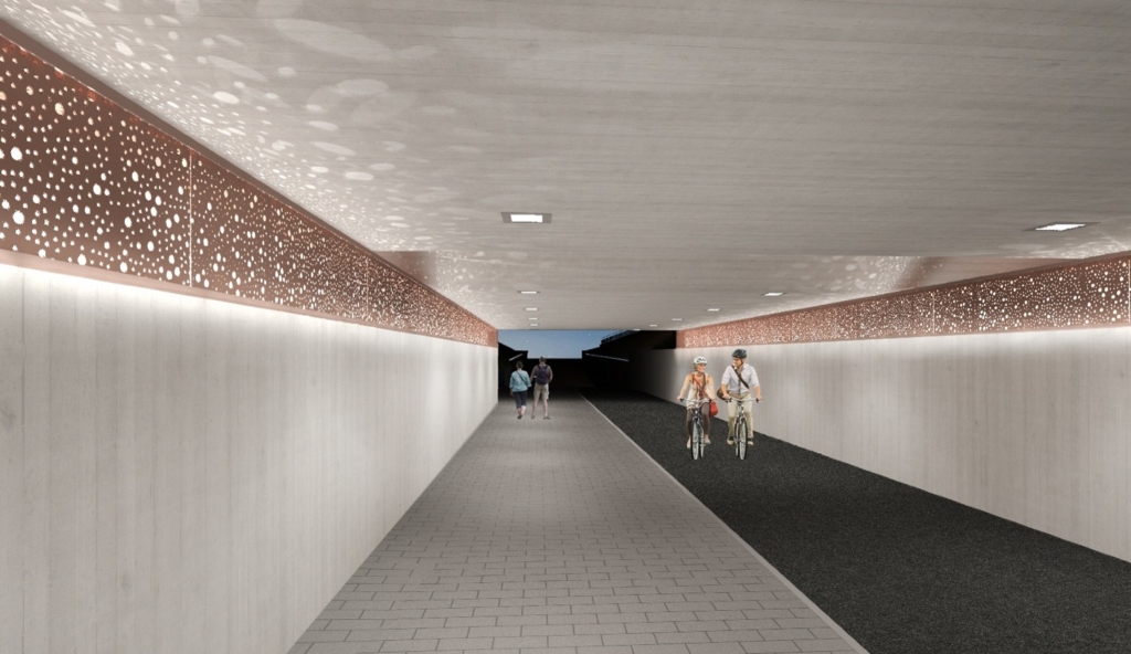 Kuva tunnelista, jossa on pyöräilijöitä ja jalankulkijoita. Tunnelin seinillä on koristeellisia valoja.