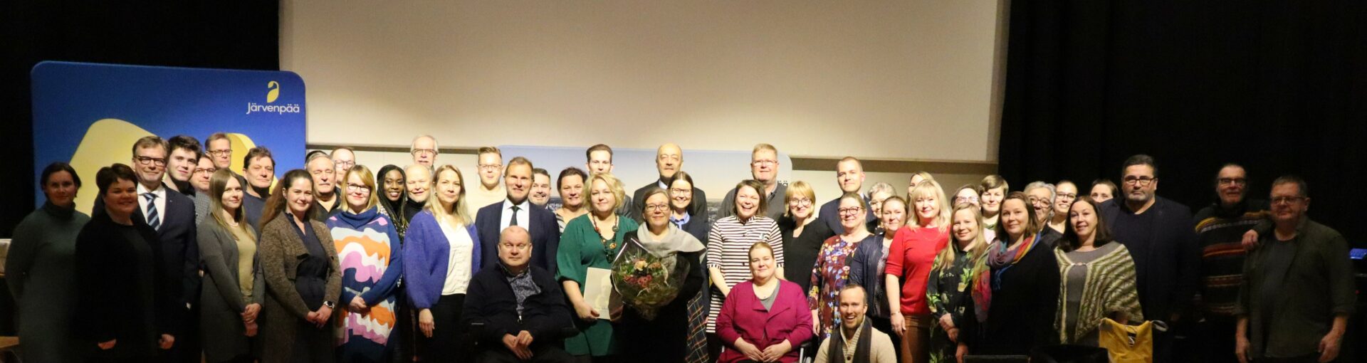 Ihmisiä ryhmäkuvassa.