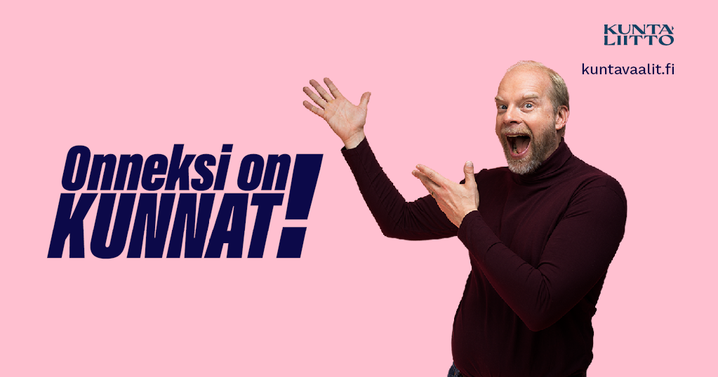 "Vaaleanpunaisella taustalla seisoo henkilö, jolla on päällään viininpunainen poolopaita. Hän osoittaa innostuneesti vasemmalle suuntautuneilla käsieleillä ja hymyilee leveästi suu auki. Kuvan vasemmassa reunassa on tummansinisellä kirjoitettu teksti 'Onneksi on KUNNAT!' korostettuna huutomerkillä. Oikeassa yläkulmassa on Kuntaliiton logo ja sen alla verkkosivun osoite 'kuntavaalit.fi'."